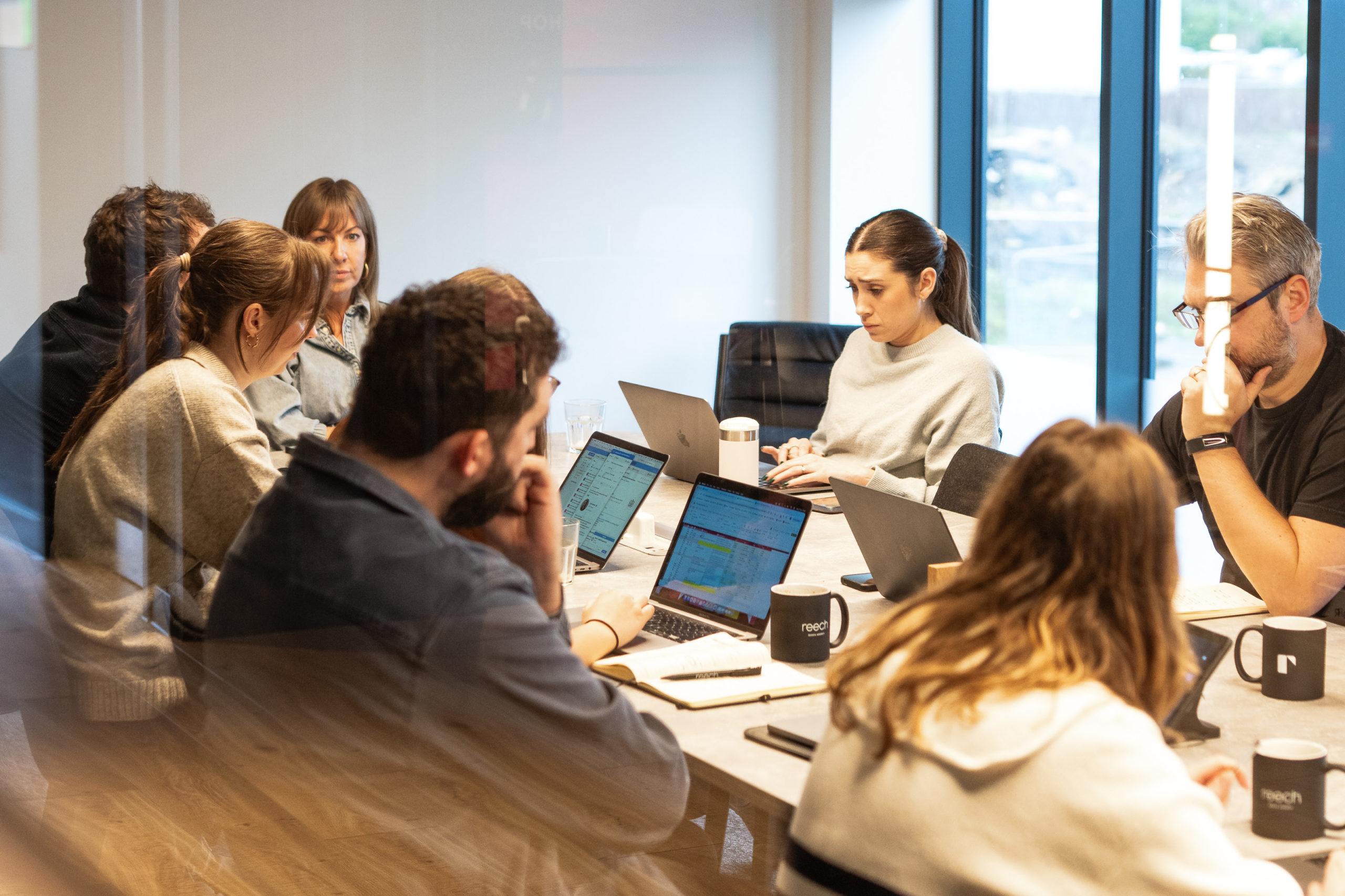 A team of marketing professionals working together around a conference table, representing full agency access and collaborative strategy.